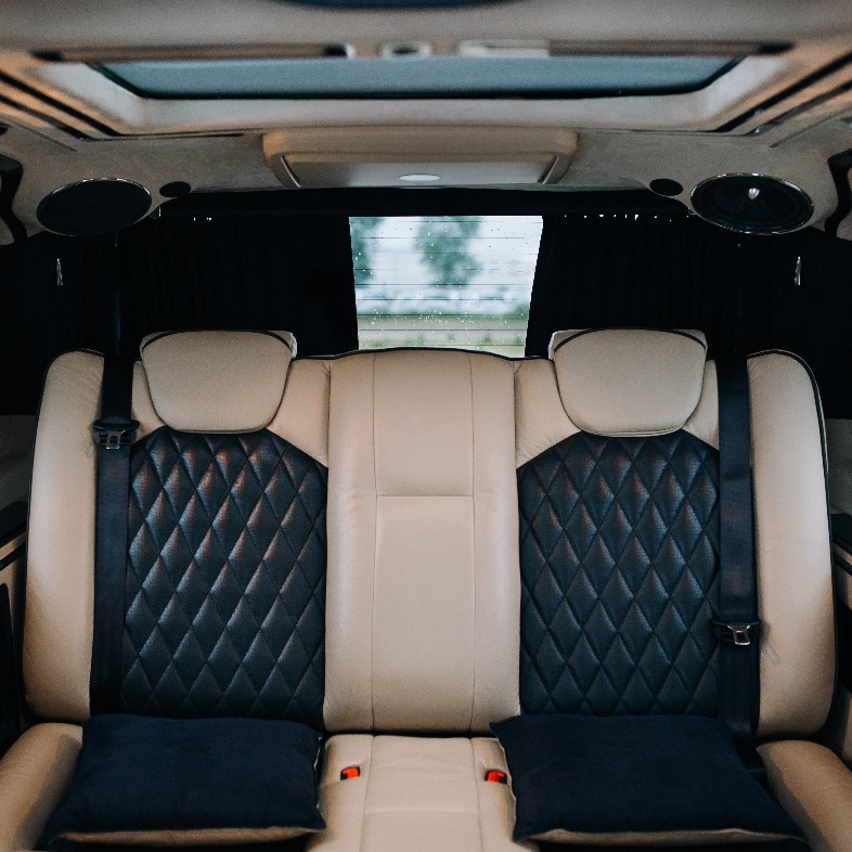 Luxuriöse Ledersitze in einem komfortablen Van. Innenraum eines luxuriösen Minivans mit Hintergrundbeleuchtung, Transferwagen