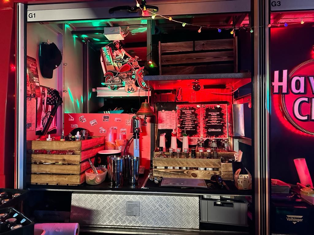 Bunt beleuchteter Imbissstand mit vielen Getränken und bunter Dekoration